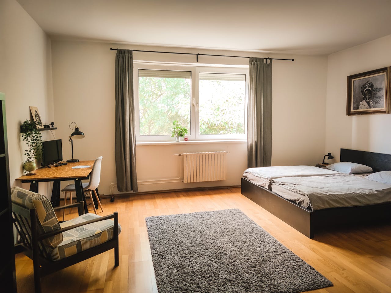 Spacious bedroom with modern decor, wooden floors, and natural light in Bratislava.
